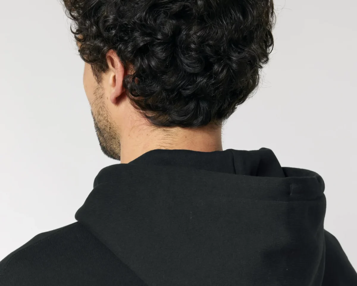 Modelo con cabello rizado en sudadera negra, transmitiendo estilo y comodidad.