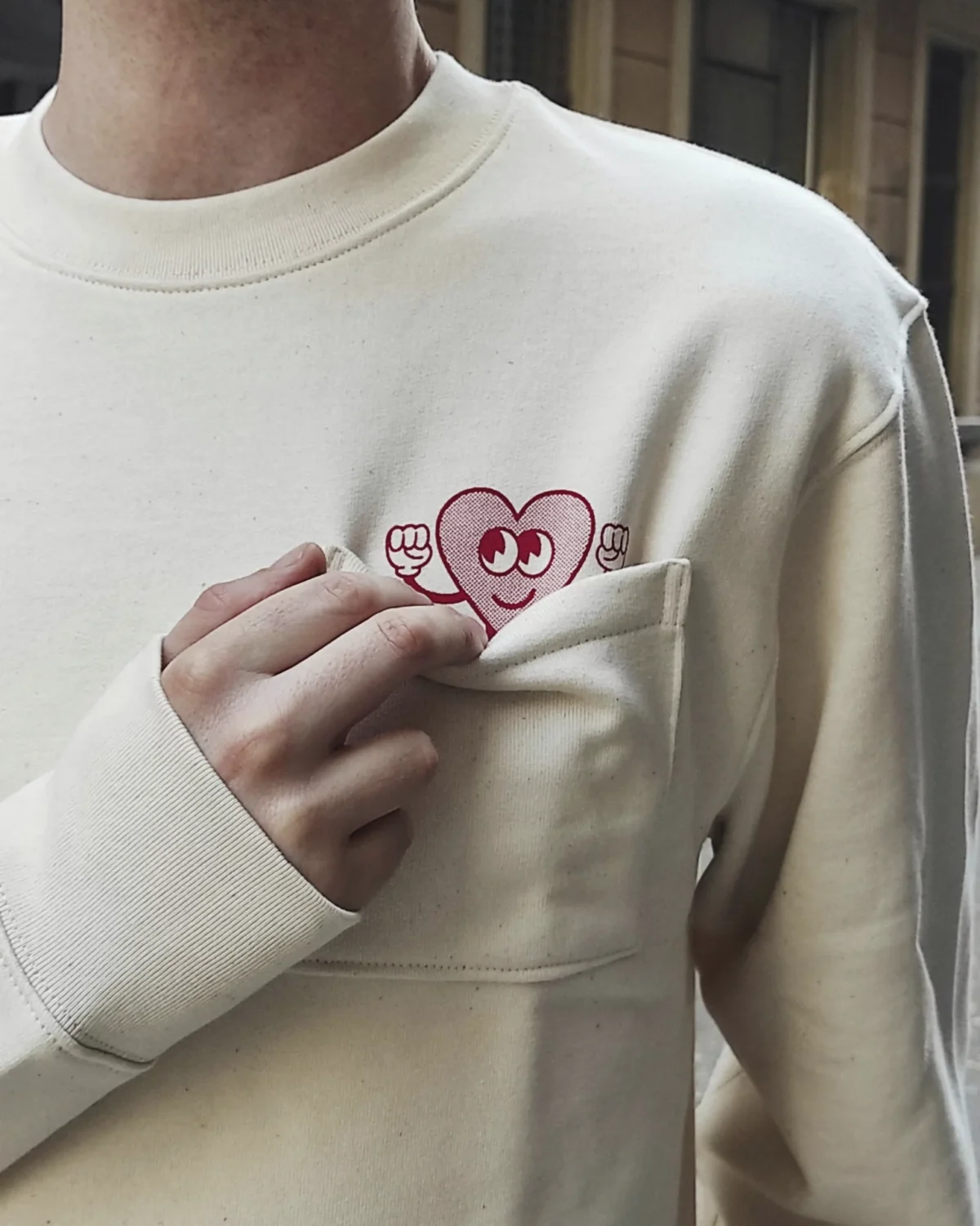 Sudadera ligera con bolsillo y divertido corazón bordado en el pecho.